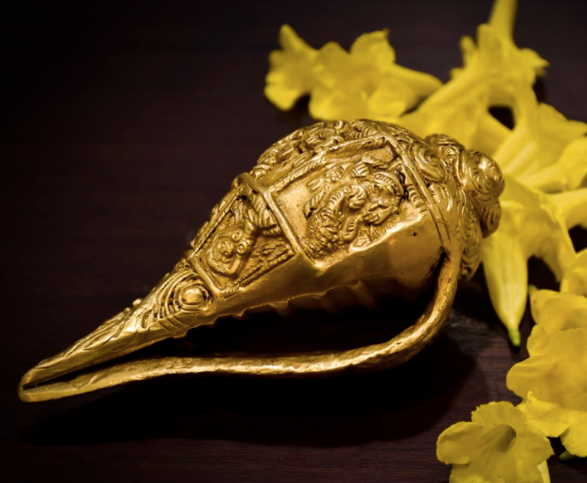 A Brass Shankh / Conch with detailed Ganesha carvings all around.