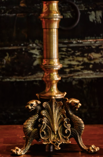 Brass Candle Stands are made of 100% Brass With Jaguar Heads carved onto a brass canvas along with other beautiful details, executed elegantly, supported by three brass legs.
