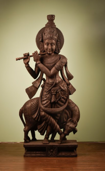 A Wooden Krishna Statue, made of mango wood, hand carved into lord krishna playing his flute.