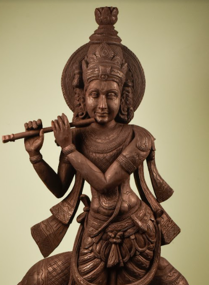 A Wooden Krishna Statue, made of mango wood, hand carved into lord krishna playing his flute.