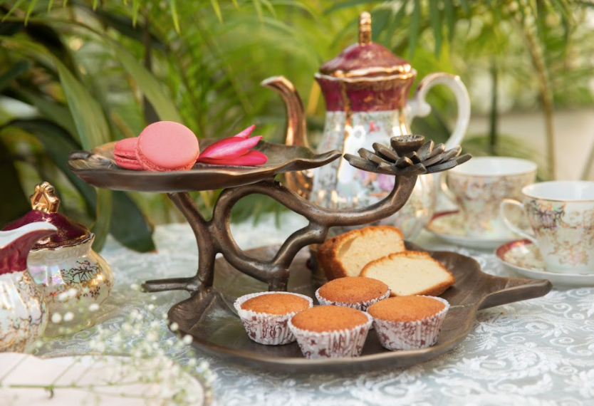 A 2-Tier, Rustic Metallic Food Stand In The Image Of A Petal With A Pencil Candle Holder.