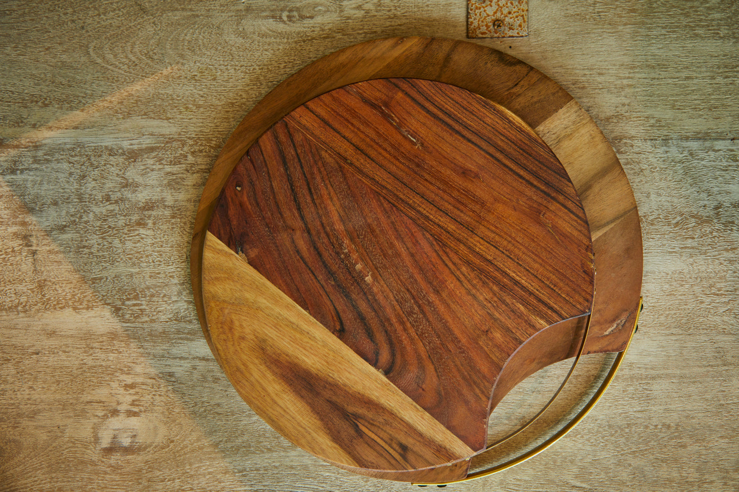 A Round Wooden Platter With A Metal Handle On One Side.